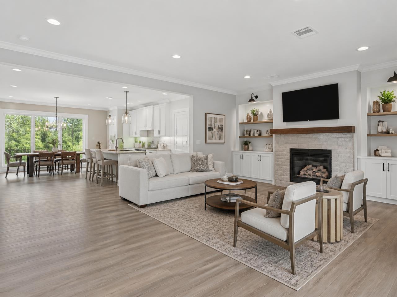 Open-concept living room remodel by BMG Remodeling with new flooring and white trim